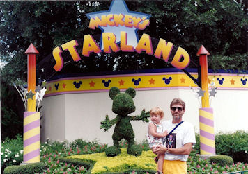 Dad holding Max in front of Mickey's Starland