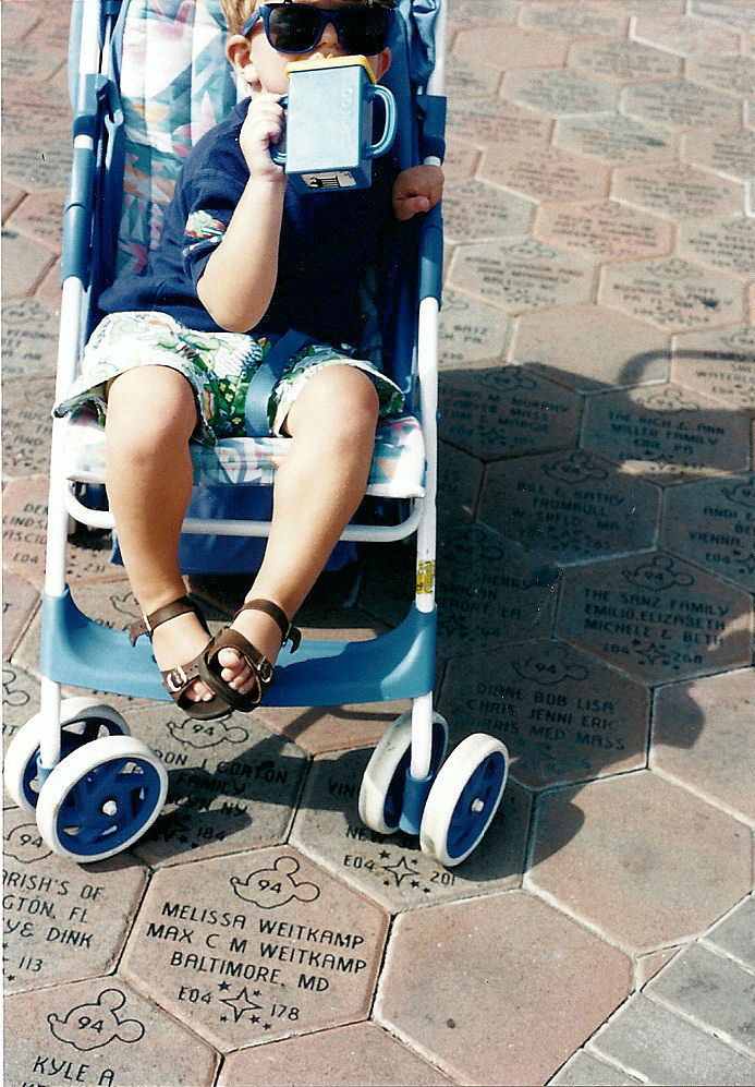 Max in stroller by plaque at Walt Disney World.