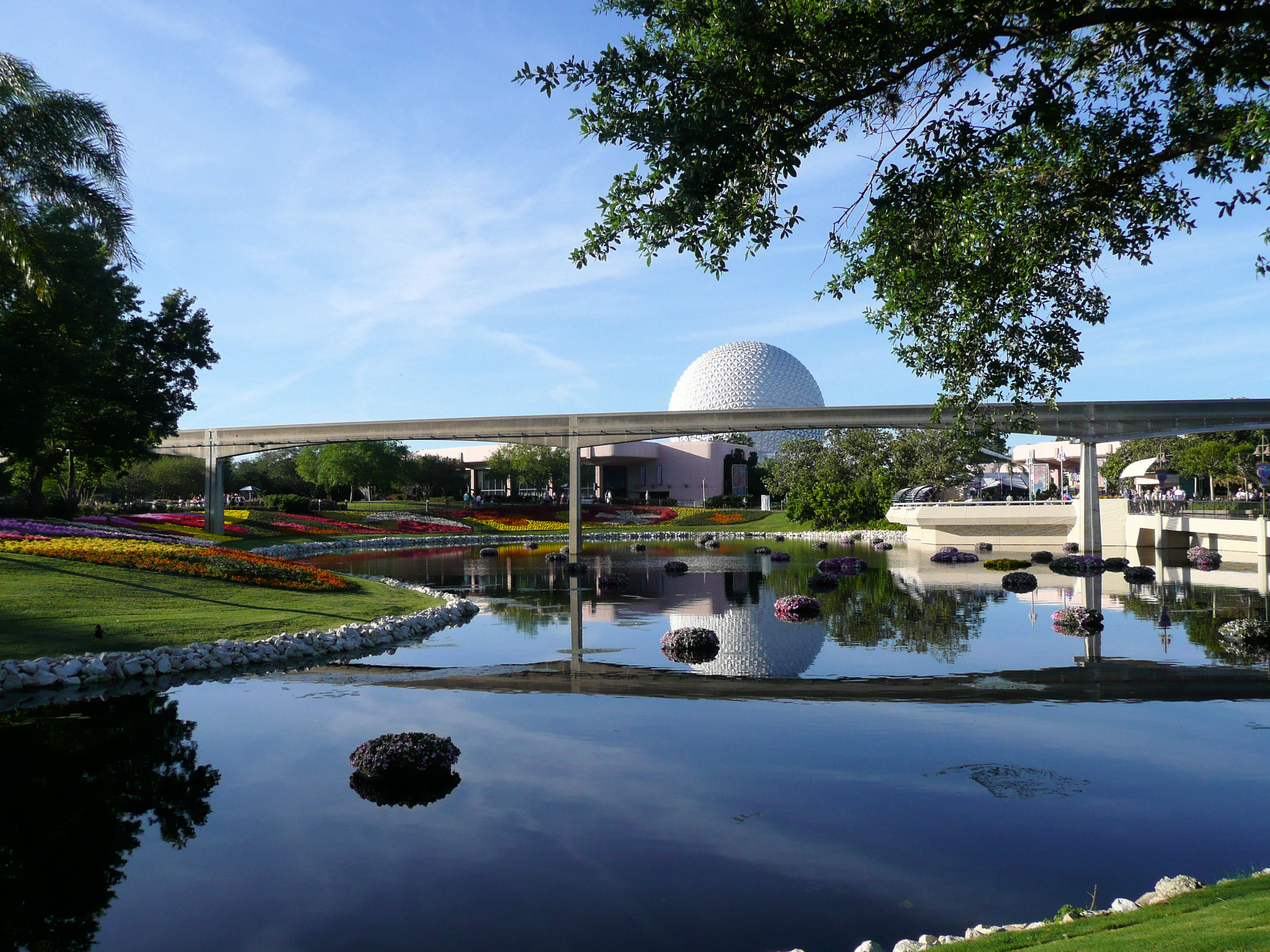 A reflective picture at EPCOT with Spaceship Earth and the monorail track.